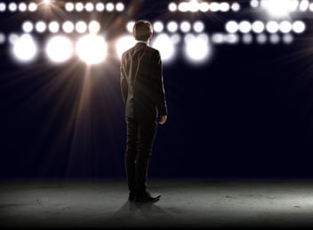 Rear view of businessman standing in lights of stage-307140-edited.jpeg