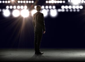 businessman standing in lights of stage